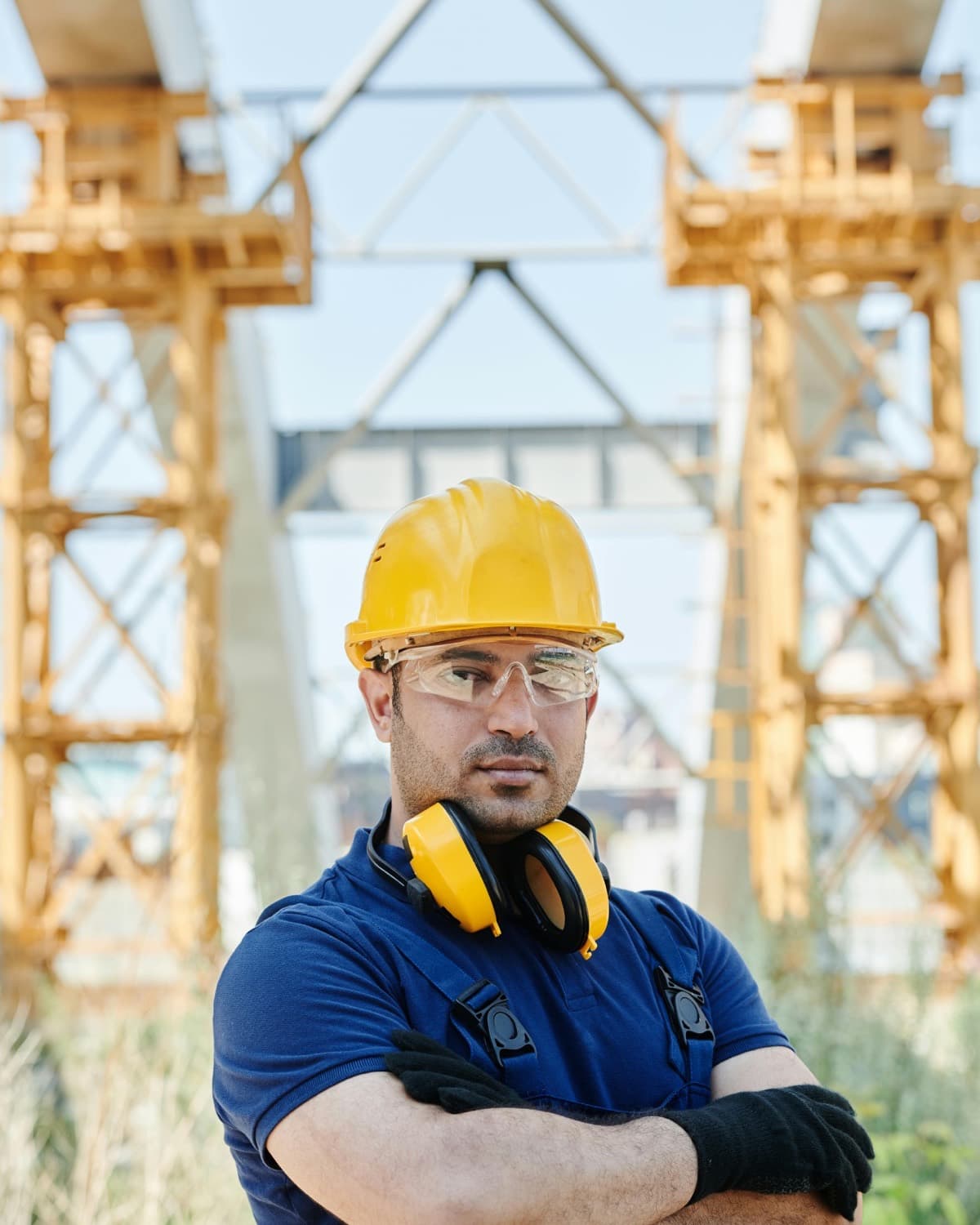 Confident engineer in protective gear and hardhat on an active industrial site