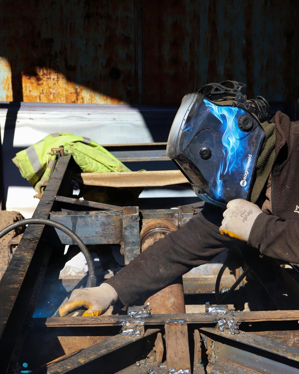 Welder at work in an outdoor industrial setting, the kind of scope IES third-party inspectors verify